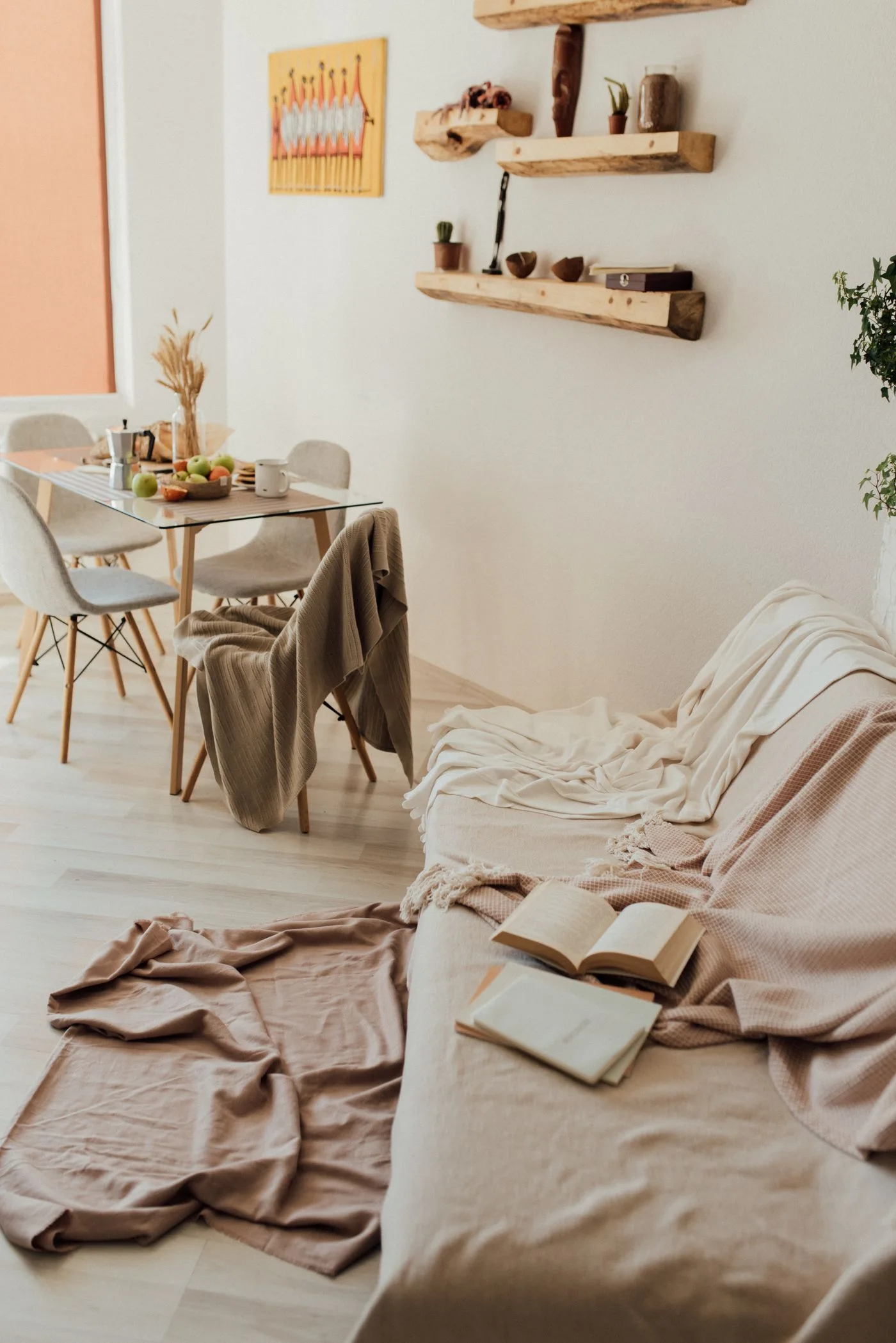 A warm and inviting living room features a cozy sofa, dining table, and artistic decor.